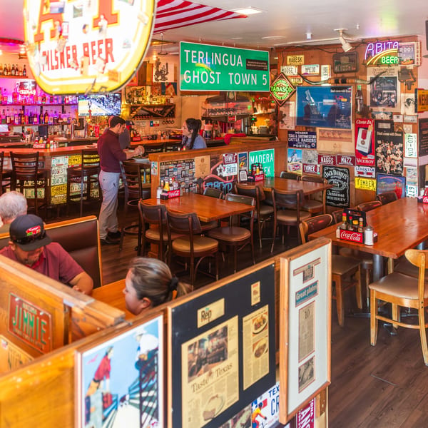 Diners seated in booths and at tables in the Texaz Grill, a steakhouse with rustic decor.